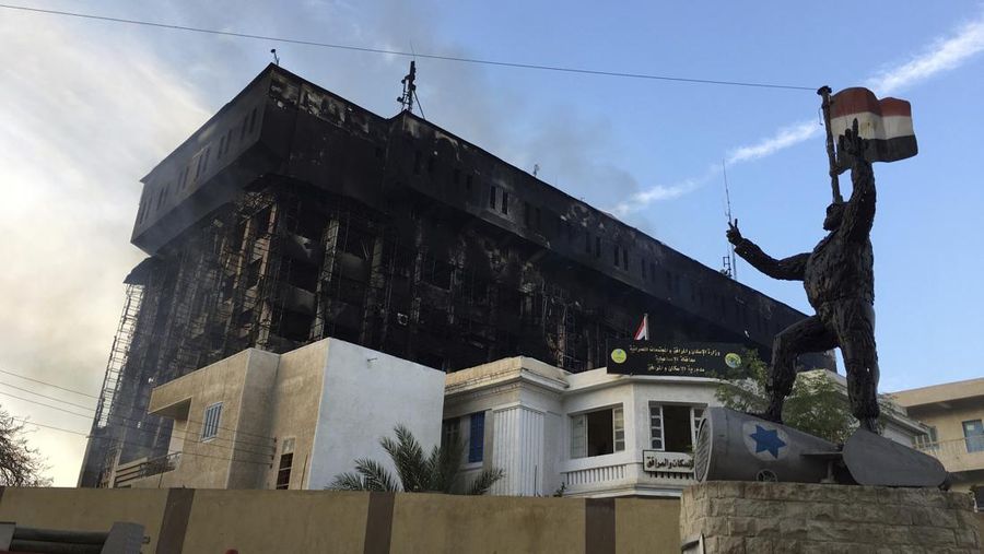 Kepulan asap terlihat dari markas polisi yang terbakar di Ismailia, Timur Laut Mesir. Senin (2/10/2023). (AP Photo/Mohammed Awad)