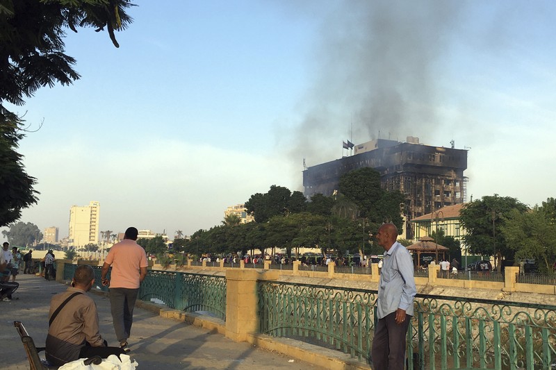 Kepulan asap terlihat dari markas polisi yang terbakar di Ismailia, Timur Laut Mesir. Senin (2/10/2023). (AP Photo/Mohammed Awad)