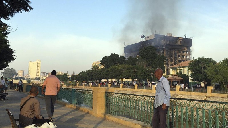 Kepulan asap terlihat dari markas polisi yang terbakar di Ismailia, Timur Laut Mesir. Senin (2/10/2023). (AP Photo/Mohammed Awad)