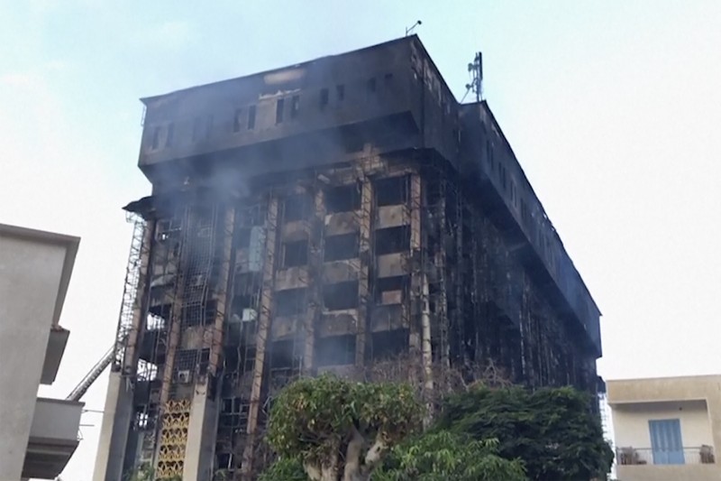 Kepulan asap terlihat dari markas polisi yang terbakar di Ismailia, Timur Laut Mesir. Senin (2/10/2023). (AP Photo/Mohammed Awad)