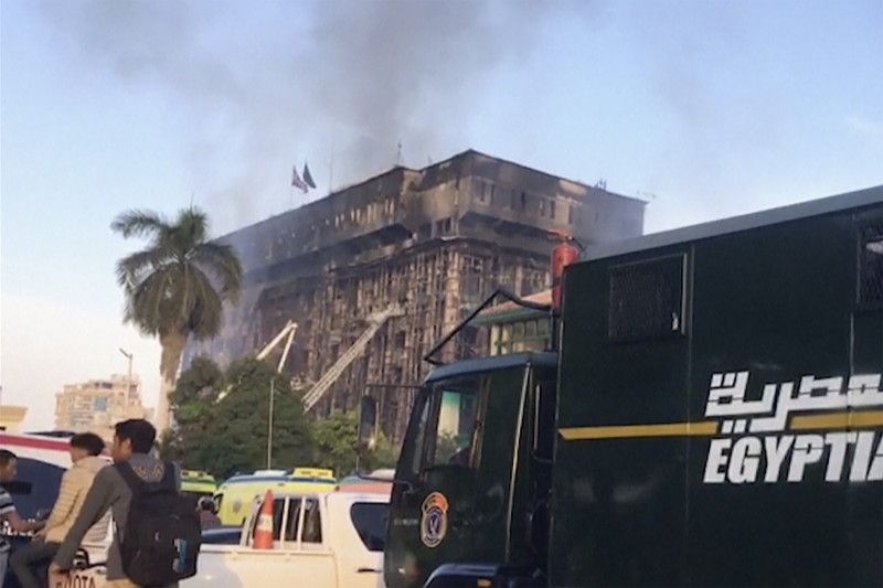Kepulan asap terlihat dari markas polisi yang terbakar di Ismailia, Timur Laut Mesir. Senin (2/10/2023). (AP Photo/Mohammed Awad)