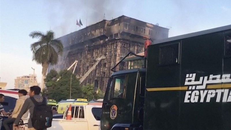Kepulan asap terlihat dari markas polisi yang terbakar di Ismailia, Timur Laut Mesir. Senin (2/10/2023). (AP Photo/Mohammed Awad)