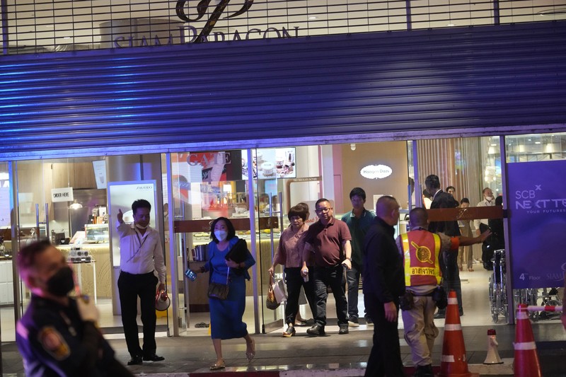 Pengunjung mengungsi dari pusat perbelanjaan di Bangkok, Thailand, Selasa, 3 Oktober 2023. Ratusan pembeli meninggalkan pusat perbelanjaan besar di pusat ibu kota Thailand, Bangkok pada Selasa sore setelah terdengar suara tembakan di dalam. (AP Photo/Sakchai Lalit)