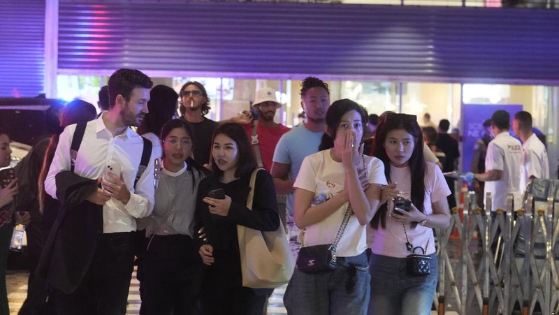 Pengunjung mengungsi dari pusat perbelanjaan di Bangkok, Thailand, Selasa, 3 Oktober 2023. Ratusan pembeli meninggalkan pusat perbelanjaan besar di pusat ibu kota Thailand, Bangkok pada Selasa sore setelah terdengar suara tembakan di dalam. (AP Photo/Sakchai Lalit)