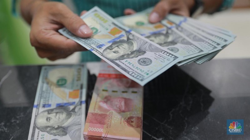 Petugas menghitung uang di tempat penukaran uang Dolar Asia, Melawai, Blok M, Jakarta, Selasa, (3/10). (CNBC Indonesia/Muhammad Sabki)