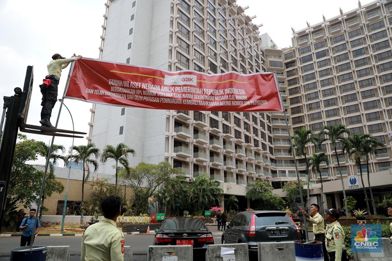 Petugas keamanan GBK memasang spanduk penyegelan Hotel Sultan di Kawasan PPKGBK, GBK, Jakarta, Rabu (4/10). Petugas keamanan GBK memasang spanduk penyegelan Hotel Sultan di Kawasan Hitel Sultan, GBK, Jakarta, Rabu (4/10). (CNBC Indonesia/Muhammad Sabki)