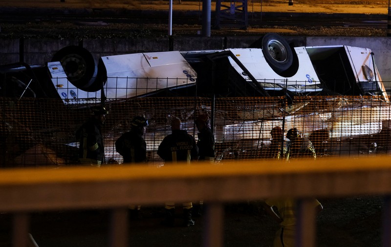 Petugas penyelamat hadir di lokasi kejadian, setelah sebuah bus jatuh dari jembatan layang di Mestre, Italia, 3 Oktober 2023. (REUTERS/Manuel Silvestri)