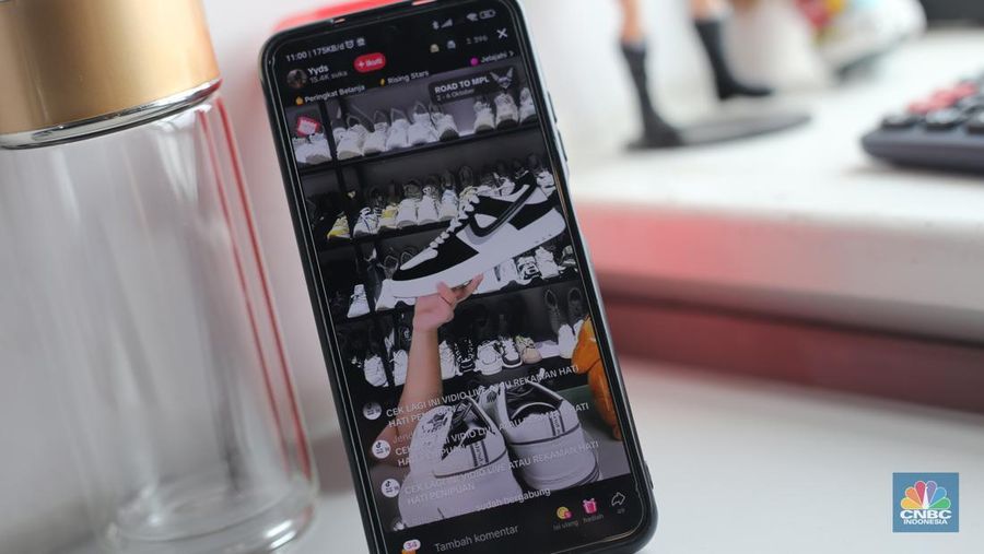 Seorang pekerja melihat berbagai produk secara langsung di TikTokshop. (CNBC Indonesia/Tias Budiarto)