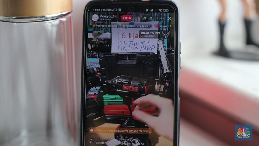 Seorang pekerja melihat berbagai produk secara langsung di TikTokshop. (CNBC Indonesia/Tias Budiarto)
