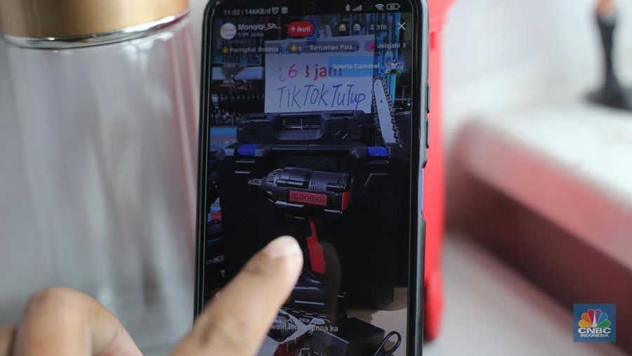Seorang pekerja melihat berbagai produk secara langsung di TikTokshop. (CNBC Indonesia/Tias Budiarto)