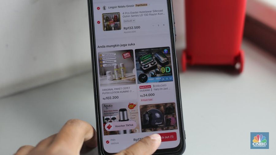 Seorang pekerja melihat berbagai produk secara langsung di TikTokshop. (CNBC Indonesia/Tias Budiarto)