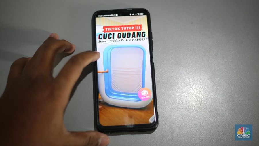 Seorang pekerja melihat berbagai produk secara langsung di TikTokshop. (CNBC Indonesia/Tias Budiarto)