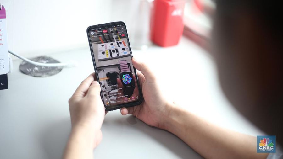 Seorang pekerja melihat berbagai produk secara langsung di TikTokshop. (CNBC Indonesia/Tias Budiarto)