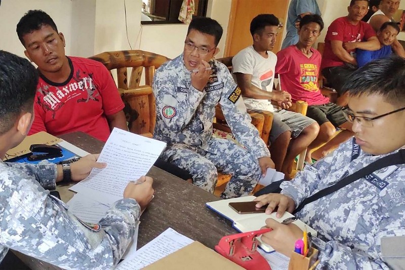 Personel Penjaga Pantai Filipina berfoto pada 3 Oktober 2023, mengambil jenazah seorang nelayan di pantai Infanta, Provinsi Pangasinan, Filipina, setelah insiden tabrakan mematikan di Laut Cina Selatan, dalam gambar selebaran yang dirilis oleh Penjaga Pantai Filipina pada 4 Oktober 2023. (Philippine Coast Guard/Handout via REUTERS)