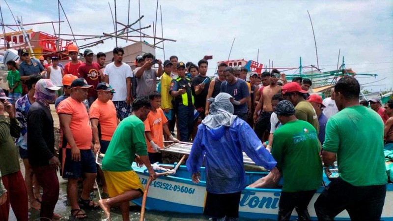 Personel Penjaga Pantai Filipina berfoto pada 3 Oktober 2023, mengambil jenazah seorang nelayan di pantai Infanta, Provinsi Pangasinan, Filipina, setelah insiden tabrakan mematikan di Laut Cina Selatan, dalam gambar selebaran yang dirilis oleh Penjaga Pantai Filipina pada 4 Oktober 2023. (Philippine Coast Guard/Handout via REUTERS)