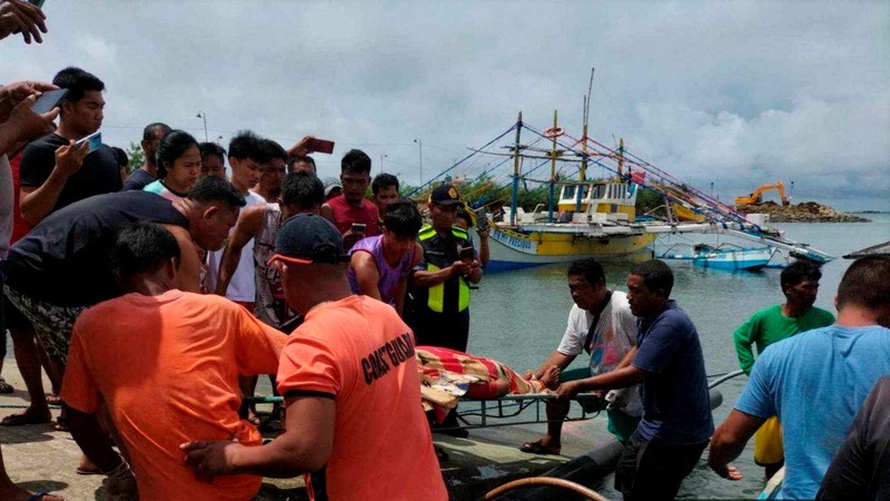 Personel Penjaga Pantai Filipina berfoto pada 3 Oktober 2023, mengambil jenazah seorang nelayan di pantai Infanta, Provinsi Pangasinan, Filipina, setelah insiden tabrakan mematikan di Laut Cina Selatan, dalam gambar selebaran yang dirilis oleh Penjaga Pantai Filipina pada 4 Oktober 2023. (Philippine Coast Guard/Handout via REUTERS)