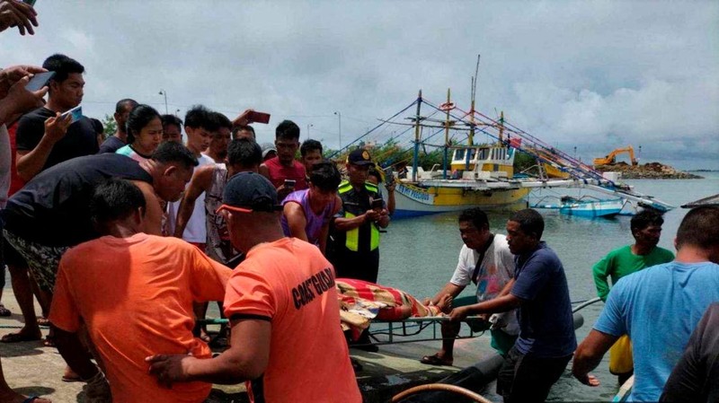 Personel Penjaga Pantai Filipina berfoto pada 3 Oktober 2023, mengambil jenazah seorang nelayan di pantai Infanta, Provinsi Pangasinan, Filipina, setelah insiden tabrakan mematikan di Laut Cina Selatan, dalam gambar selebaran yang dirilis oleh Penjaga Pantai Filipina pada 4 Oktober 2023. (Philippine Coast Guard/Handout via REUTERS)