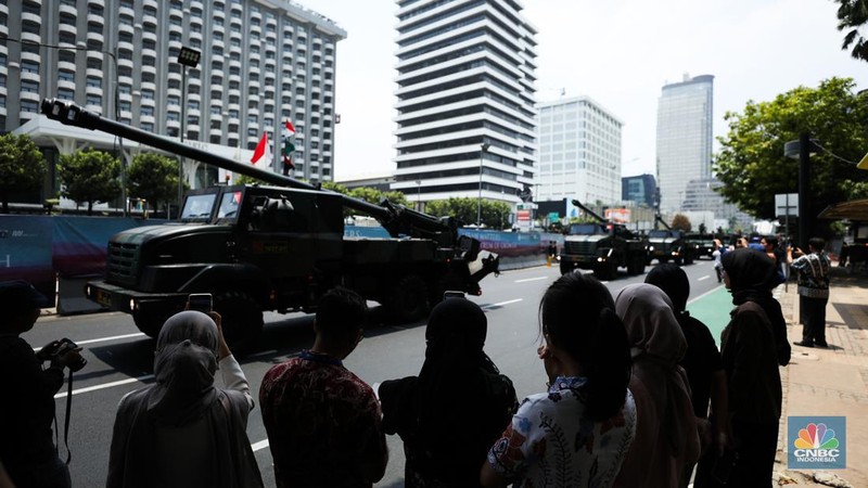 Warga menyaksikan parade militer HUT TNI ke 78 di Jakarta, Kamis (5/10/2023). (CNBC Indonesia/Tri Susilo)