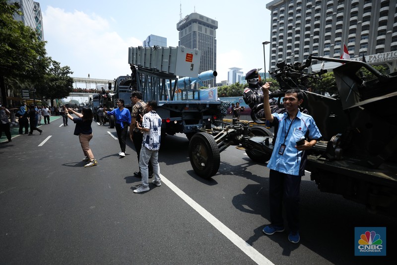 Warga menyaksikan parade militer HUT TNI ke 78 di Jakarta, Kamis (5/10/2023). (CNBC Indonesia/Tri Susilo)