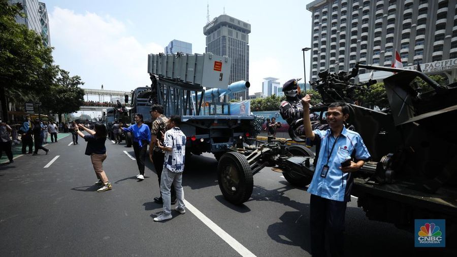 Warga menyaksikan parade militer HUT TNI ke 78 di Jakarta, Kamis (5/10/2023). (CNBC Indonesia/Tri Susilo)