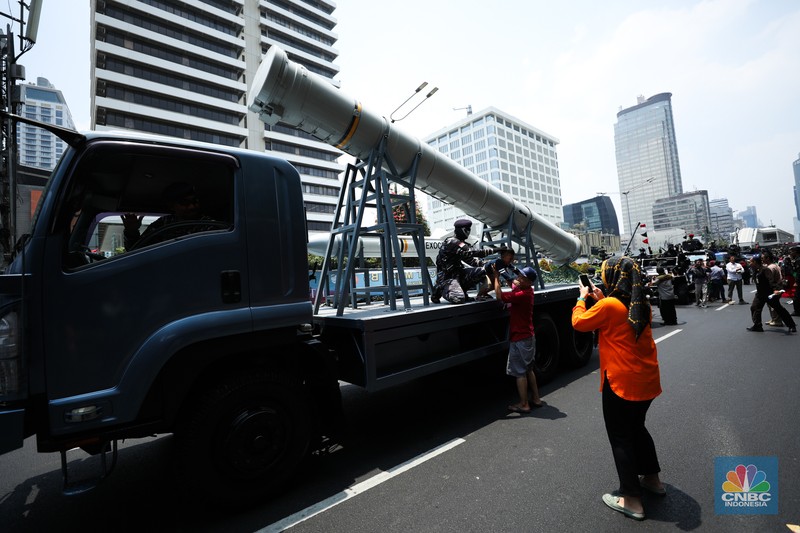 Warga menyaksikan parade militer HUT TNI ke 78 di Jakarta, Kamis (5/10/2023). (CNBC Indonesia/Tri Susilo)