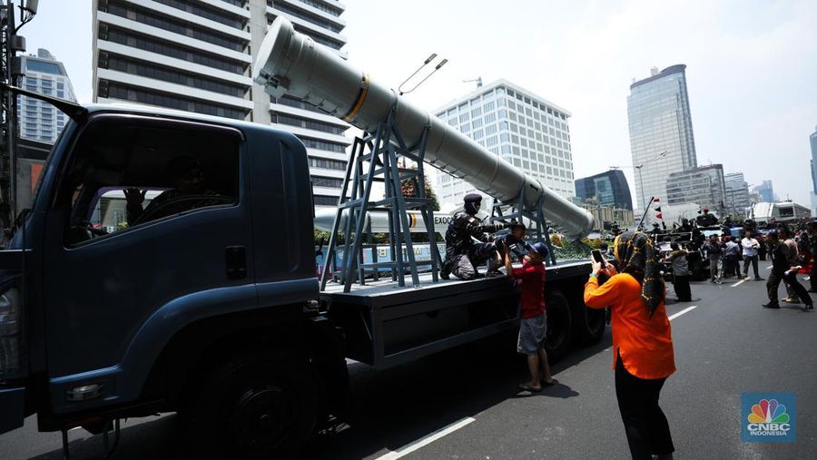 Warga menyaksikan parade militer HUT TNI ke 78 di Jakarta, Kamis (5/10/2023). (CNBC Indonesia/Tri Susilo)
