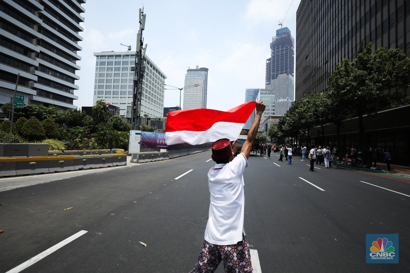 Warga menyaksikan parade militer HUT TNI ke 78 di Jakarta, Kamis (5/10/2023). (CNBC Indonesia/Tri Susilo)