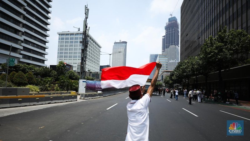 Warga menyaksikan parade militer HUT TNI ke 78 di Jakarta, Kamis (5/10/2023). (CNBC Indonesia/Tri Susilo)