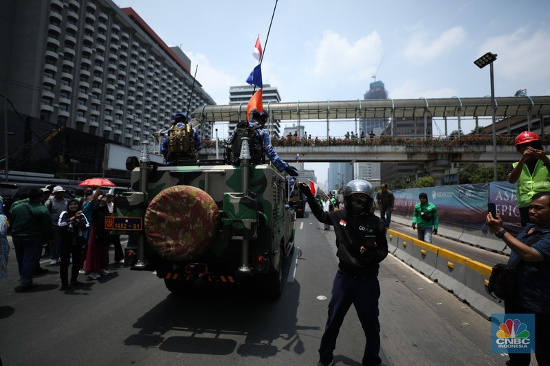 Warga menyaksikan parade militer HUT TNI ke 78 di Jakarta, Kamis (5/10/2023). (CNBC Indonesia/Tri Susilo)