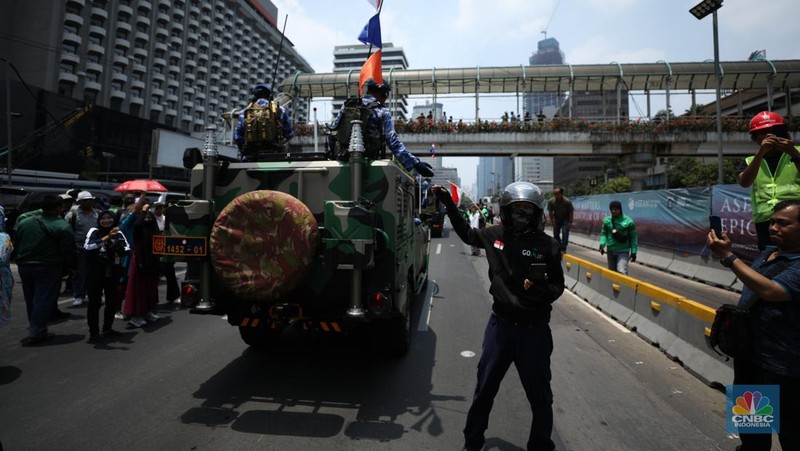 Warga menyaksikan parade militer HUT TNI ke 78 di Jakarta, Kamis (5/10/2023). (CNBC Indonesia/Tri Susilo)