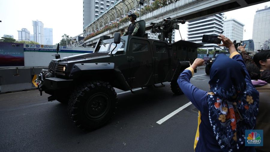 Warga menyaksikan parade militer HUT TNI ke 78 di Jakarta, Kamis (5/10/2023). (CNBC Indonesia/Tri Susilo)