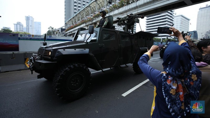 Warga menyaksikan parade militer HUT TNI ke 78 di Jakarta, Kamis (5/10/2023). (CNBC Indonesia/Tri Susilo)