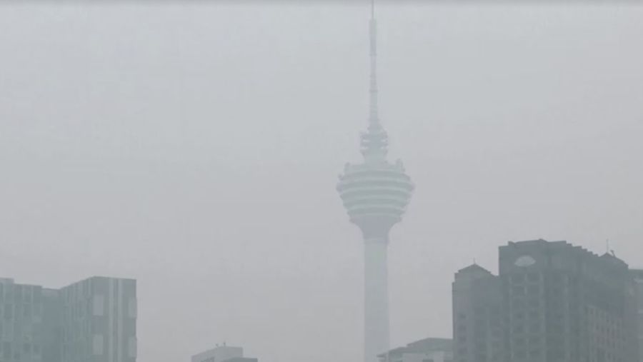 Pria berjalan melewati Pusat Kota Kuala Lumpur yang diselimuti kabut di Kuala Lumpur, Malaysia 3 Oktober 2023. (REUTERS/Hasnoor Hussain)