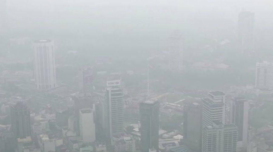 Pria berjalan melewati Pusat Kota Kuala Lumpur yang diselimuti kabut di Kuala Lumpur, Malaysia 3 Oktober 2023. (REUTERS/Hasnoor Hussain)
