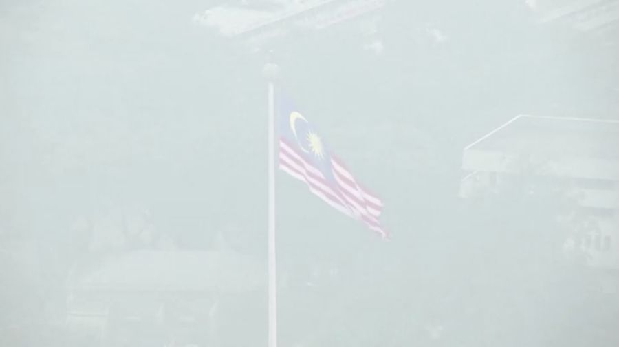 Pria berjalan melewati Pusat Kota Kuala Lumpur yang diselimuti kabut di Kuala Lumpur, Malaysia 3 Oktober 2023. (REUTERS/Hasnoor Hussain)