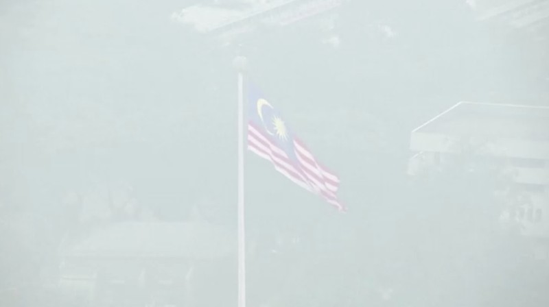 Pria berjalan melewati Pusat Kota Kuala Lumpur yang diselimuti kabut di Kuala Lumpur, Malaysia 3 Oktober 2023. (REUTERS/Hasnoor Hussain)