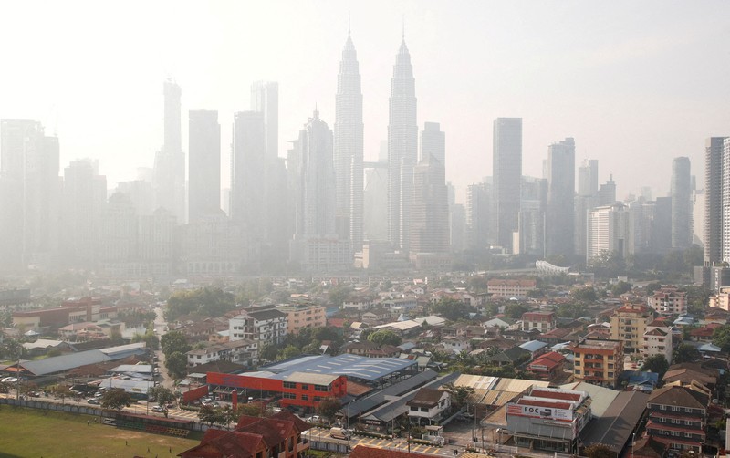 Pria berjalan melewati Pusat Kota Kuala Lumpur yang diselimuti kabut di Kuala Lumpur, Malaysia 3 Oktober 2023. Pria berjalan melewati Pusat Kota Kuala Lumpur yang diselimuti kabut di Kuala Lumpur, Malaysia 3 Oktober 2023. (REUTERS/Hasnoor Hussain)