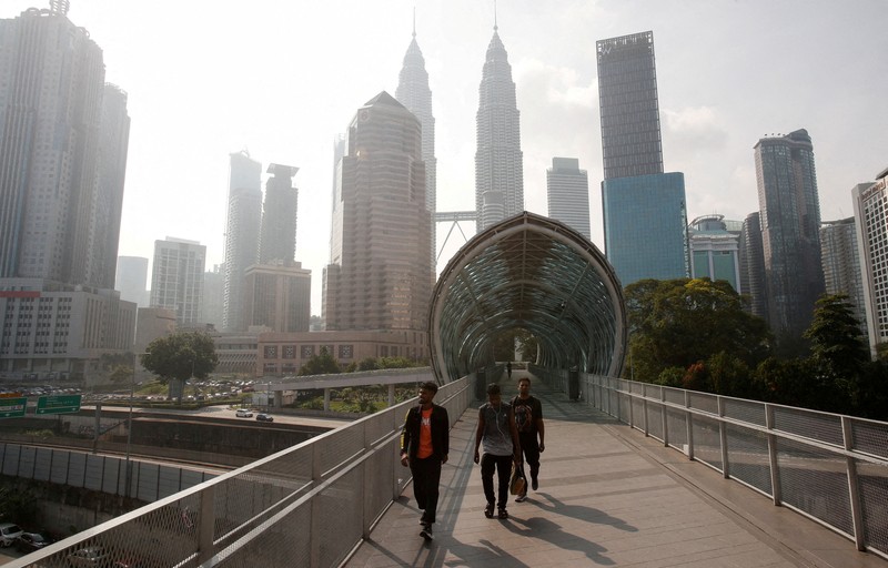 Pria berjalan melewati Pusat Kota Kuala Lumpur yang diselimuti kabut di Kuala Lumpur, Malaysia 3 Oktober 2023. Pria berjalan melewati Pusat Kota Kuala Lumpur yang diselimuti kabut di Kuala Lumpur, Malaysia 3 Oktober 2023. (REUTERS/Hasnoor Hussain)