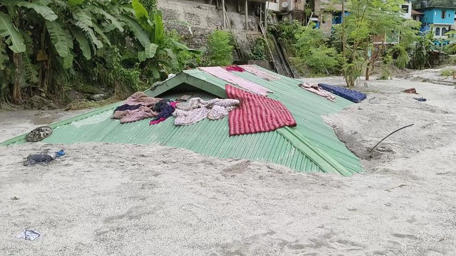 Sebuah rumah terendam sebagian akibat naiknya permukaan air di sepanjang tepian Sungai Teesta saat banjir di Teesta Bazaar di Distrik Kalimpong, Benggala Barat, India 4 Oktober 2023. (REUTERS/Brihat Rai)