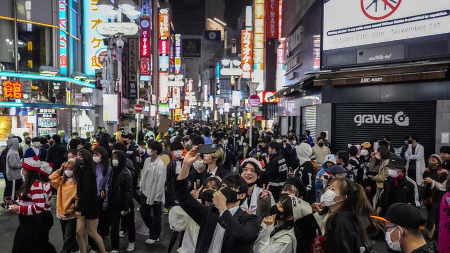 Sejumlah warga mengenakan kostum halloween berpose untuk berfoto saat ribuan orang terus berkumpul di distrik Shibuya, tempat berkumpulnya Halloween yang populer. (AP Photo/Kiichiro Sato/File Foto)