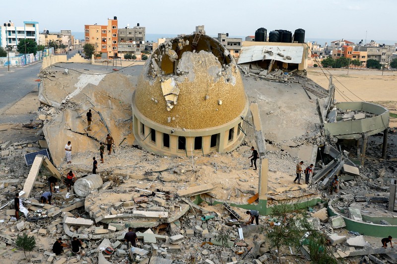 Palestinians inspect a mosque destroyed in Israeli strikes in Khan Younis, in the southern Gaza Strip, October 8, 2023. REUTERS/Ibraheem Abu Mustafa     TPX IMAGES OF THE DAY