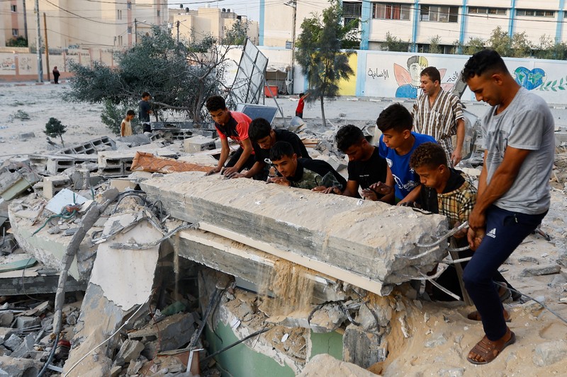 Palestinians inspect a mosque destroyed in Israeli strikes in Khan Younis, in the southern Gaza Strip, October 8, 2023. REUTERS/Ibraheem Abu Mustafa     TPX IMAGES OF THE DAY