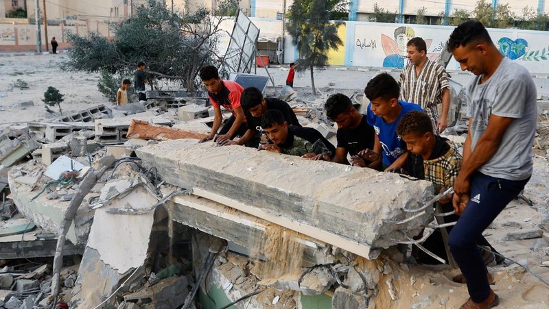 Palestinians inspect a mosque destroyed in Israeli strikes in Khan Younis, in the southern Gaza Strip, October 8, 2023. REUTERS/Ibraheem Abu Mustafa     TPX IMAGES OF THE DAY