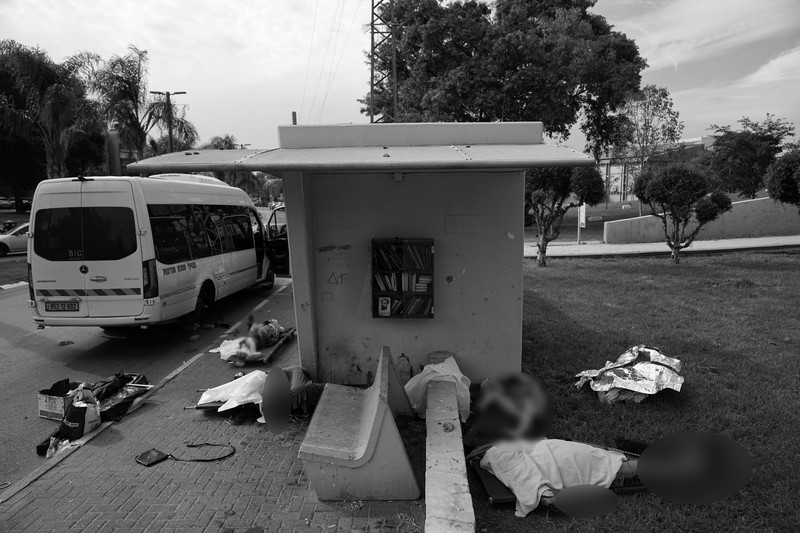 Israel Palestinians Israeli soldiers walk by a killed Palestinian militant near the Gaza strip outside Ashkelon, Israel, on Saturday, Oct. 7, 2023. Palestinian militants in the Gaza Strip infiltrated Saturday into southern Israel and fired thousands of rockets into the country while Israel began striking targets in Gaza in response. (AP Photo/Ohad Zwigenberg)