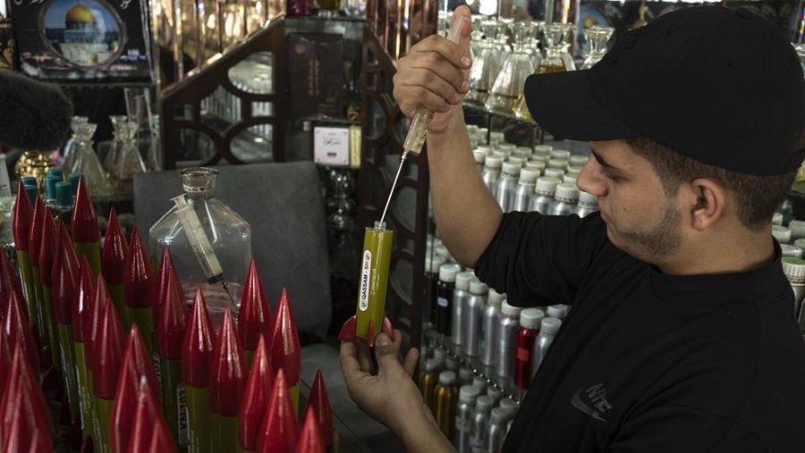 Belal Abu Saraya poses with a perfume container representing rockets used against Israel in a perfume store against Israel in past conflicts at his shop in Gaza City on Thursday, Oct. 5, 2023. AP Photo/Fatima Shbair)