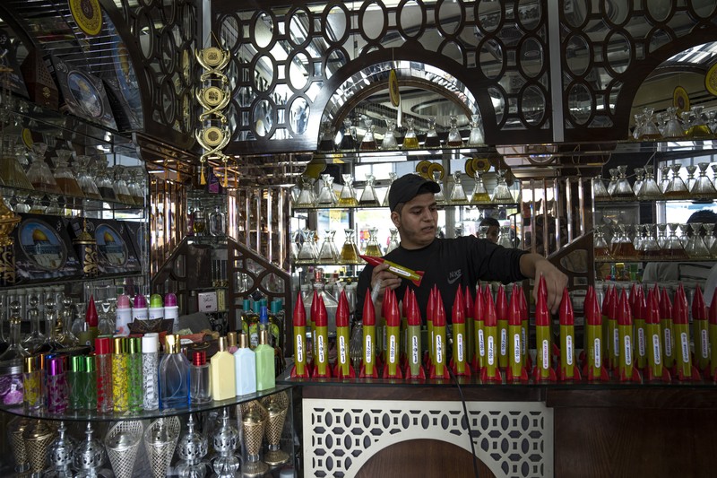 Belal Abu Saraya poses with a perfume container representing rockets used against Israel in a perfume store against Israel in past conflicts at his shop in Gaza City on Thursday, Oct. 5, 2023. AP Photo/Fatima Shbair)