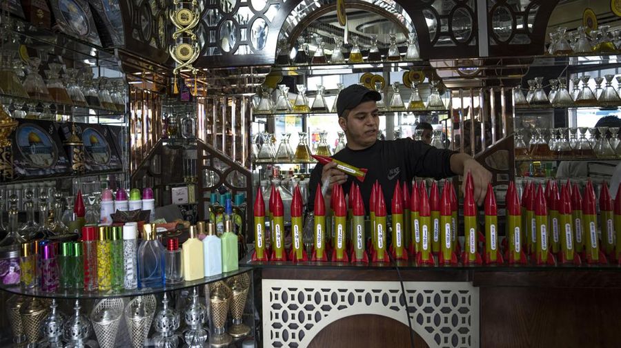 Belal Abu Saraya poses with a perfume container representing rockets used against Israel in a perfume store against Israel in past conflicts at his shop in Gaza City on Thursday, Oct. 5, 2023. AP Photo/Fatima Shbair)