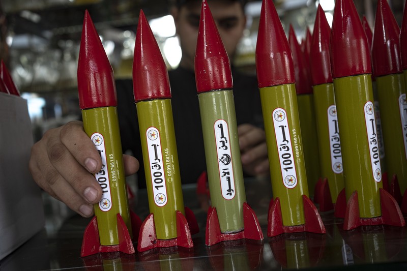 Belal Abu Saraya poses with a perfume container representing rockets used against Israel in a perfume store against Israel in past conflicts at his shop in Gaza City on Thursday, Oct. 5, 2023. AP Photo/Fatima Shbair)