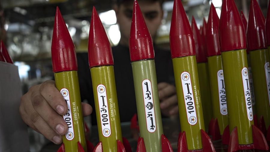 Belal Abu Saraya poses with a perfume container representing rockets used against Israel in a perfume store against Israel in past conflicts at his shop in Gaza City on Thursday, Oct. 5, 2023. AP Photo/Fatima Shbair)