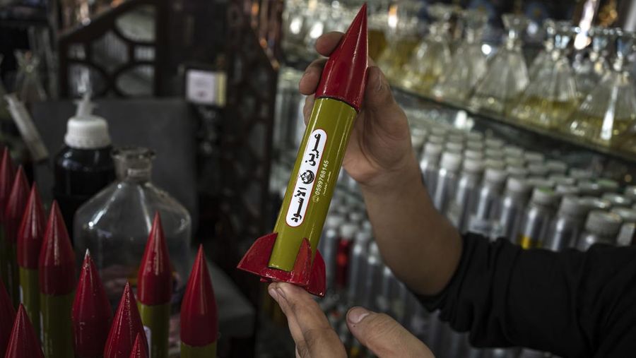 Belal Abu Saraya poses with a perfume container representing rockets used against Israel in a perfume store against Israel in past conflicts at his shop in Gaza City on Thursday, Oct. 5, 2023. AP Photo/Fatima Shbair)